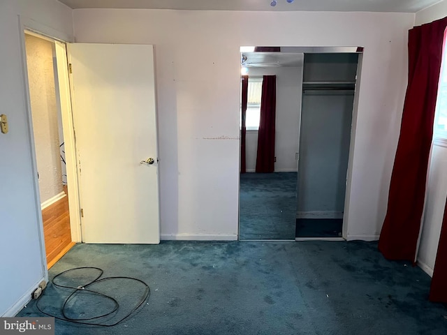 unfurnished bedroom featuring a closet and dark colored carpet