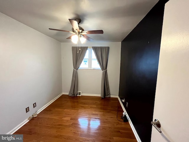 unfurnished room featuring ceiling fan and dark hardwood / wood-style flooring