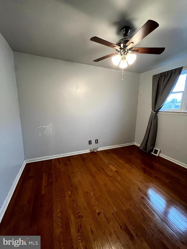 spare room featuring ceiling fan and dark hardwood / wood-style flooring