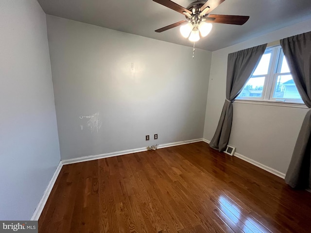 empty room with ceiling fan and dark hardwood / wood-style floors