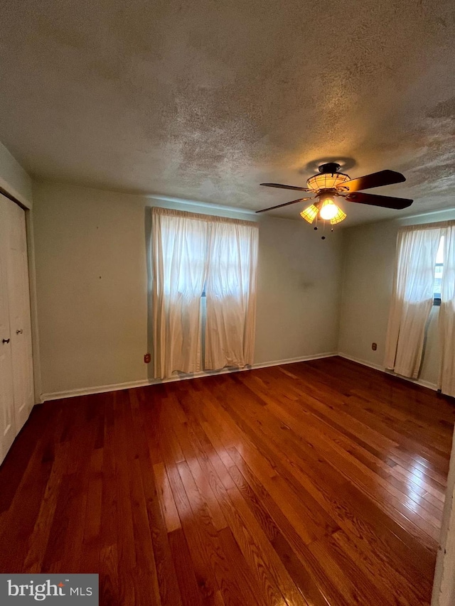 unfurnished room featuring hardwood / wood-style flooring, a textured ceiling, and a wealth of natural light