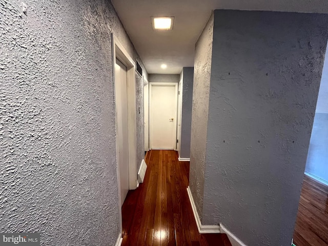 hallway with dark hardwood / wood-style flooring