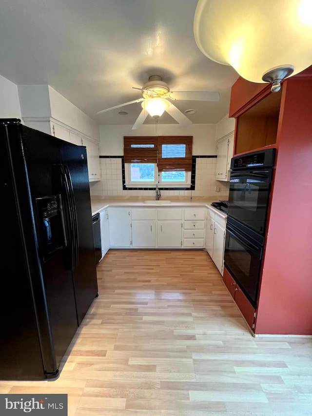 kitchen featuring sink, backsplash, white cabinets, and black appliances