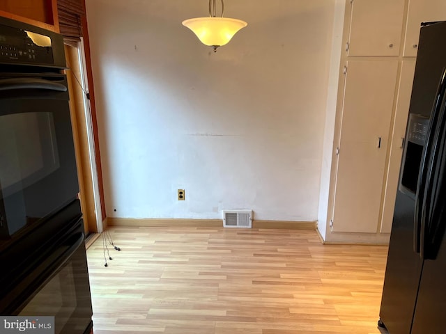 unfurnished dining area featuring light wood-type flooring