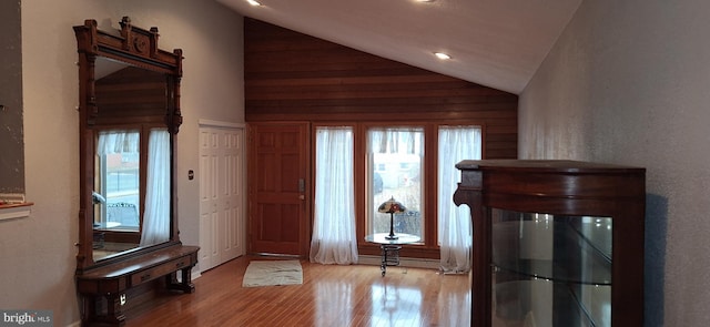 foyer entrance featuring light wood-type flooring, a wealth of natural light, and lofted ceiling