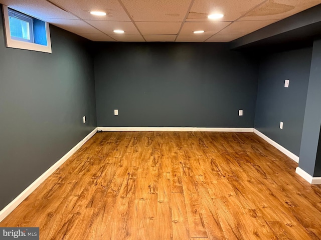 basement with wood-type flooring and a drop ceiling