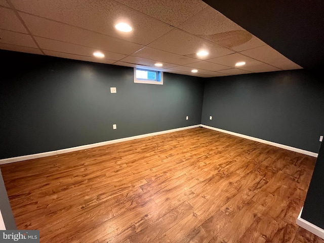 basement with wood-type flooring and a drop ceiling