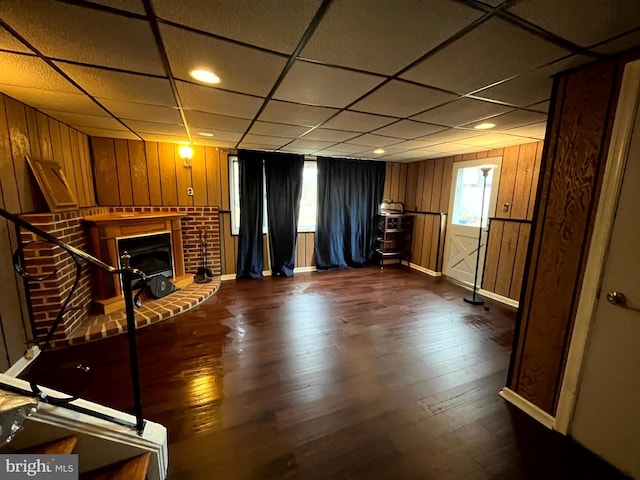 unfurnished living room with dark wood-type flooring and a drop ceiling