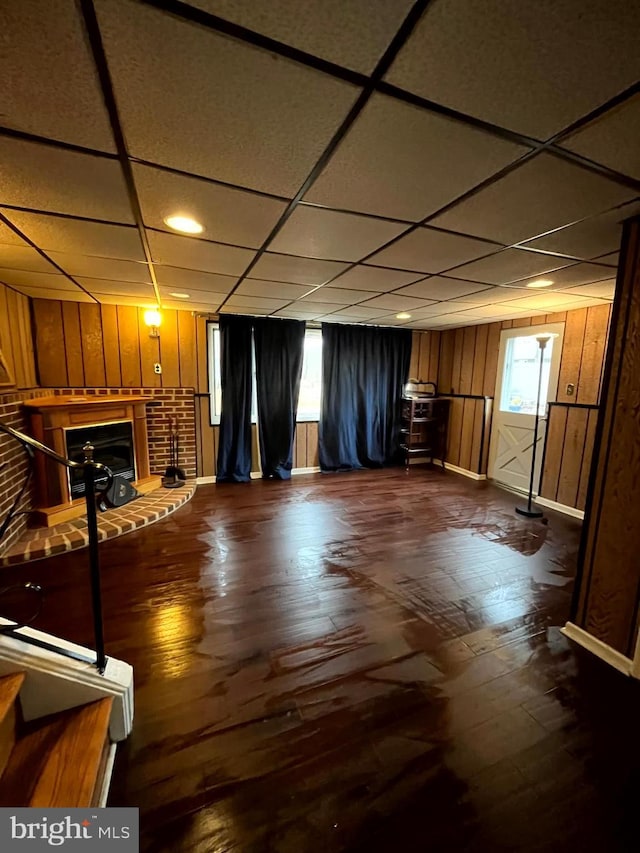 basement featuring dark wood-type flooring and a drop ceiling