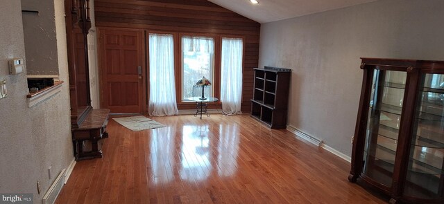 foyer featuring light wood-type flooring, a wealth of natural light, and lofted ceiling