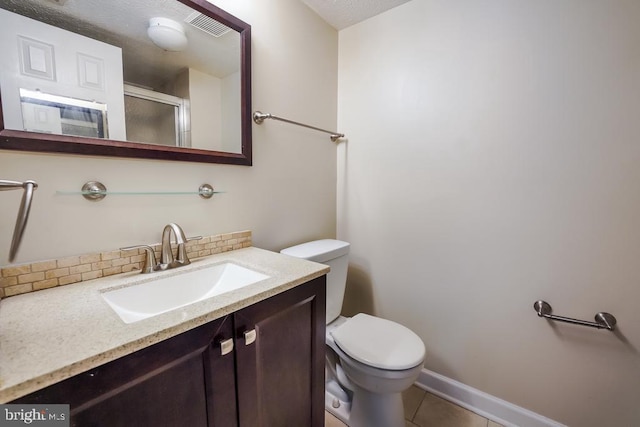 bathroom featuring tile patterned floors, a shower with door, vanity, backsplash, and toilet