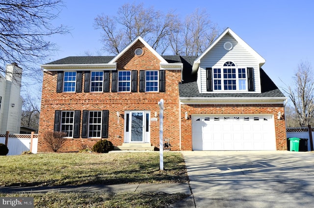 colonial-style house featuring a garage and a front yard