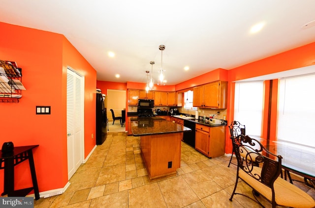 kitchen with sink, a kitchen island, pendant lighting, decorative backsplash, and black appliances