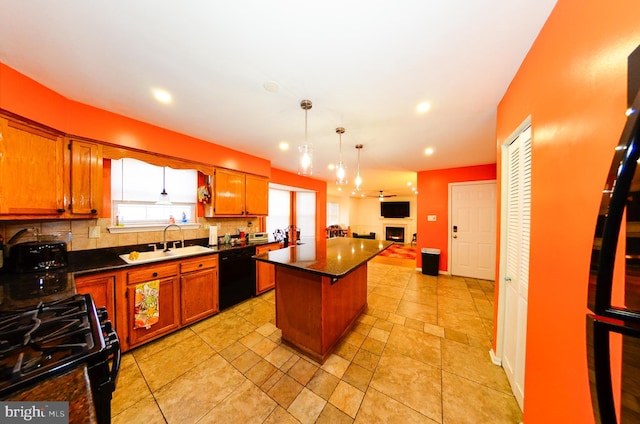 kitchen with tasteful backsplash, sink, hanging light fixtures, a center island, and black appliances