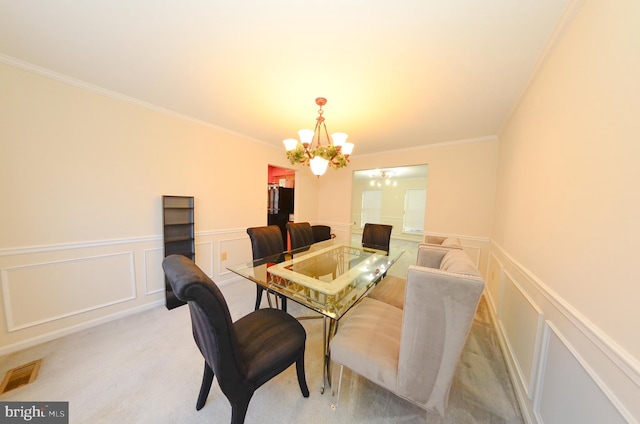 carpeted dining room featuring crown molding and an inviting chandelier