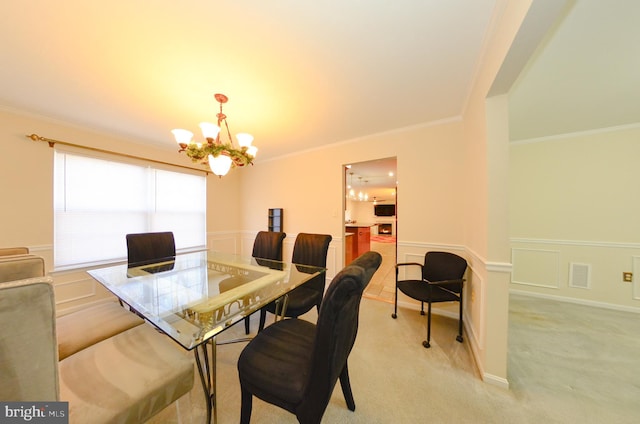 carpeted dining space featuring ornamental molding and a chandelier