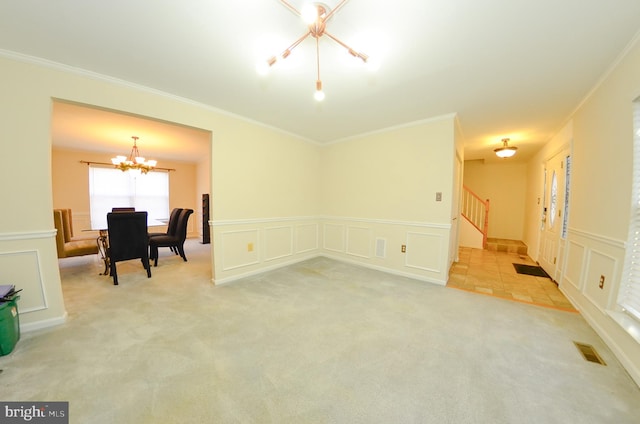 unfurnished room with an inviting chandelier, crown molding, and light carpet