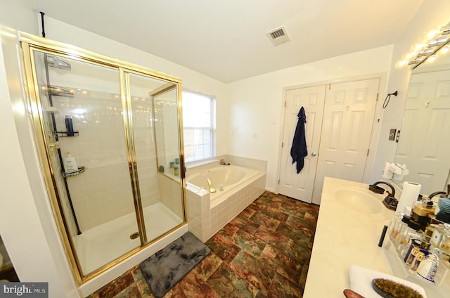 bathroom featuring vanity and independent shower and bath