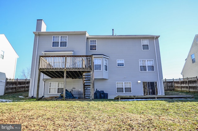 back of house with a deck and a lawn