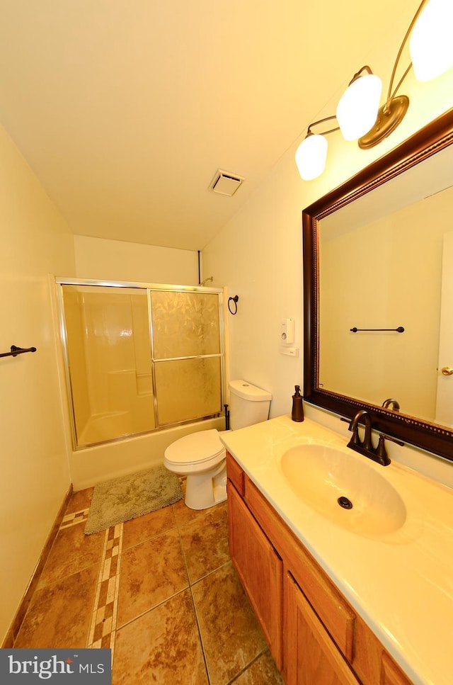 full bathroom featuring shower / bath combination with glass door, tile patterned floors, vanity, and toilet