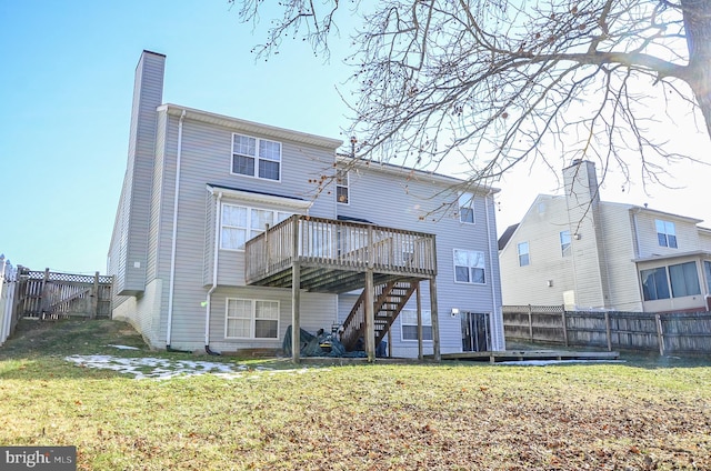 rear view of property with a wooden deck and a lawn