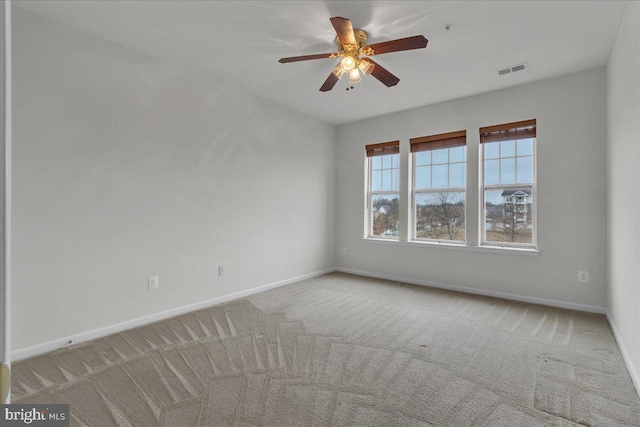 carpeted spare room with ceiling fan