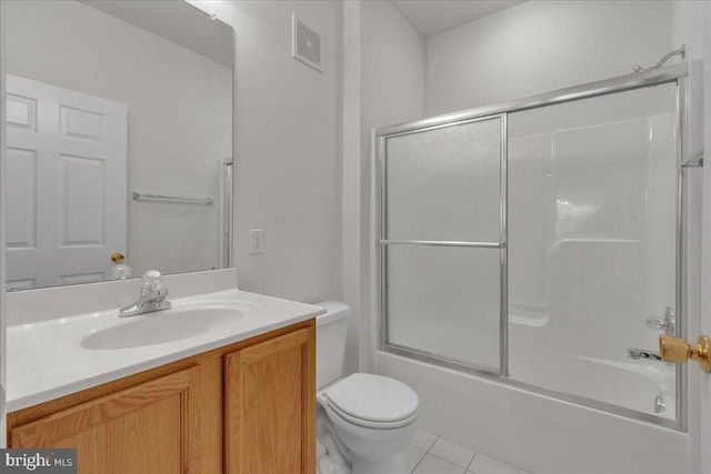 full bathroom with vanity, bath / shower combo with glass door, tile patterned floors, and toilet