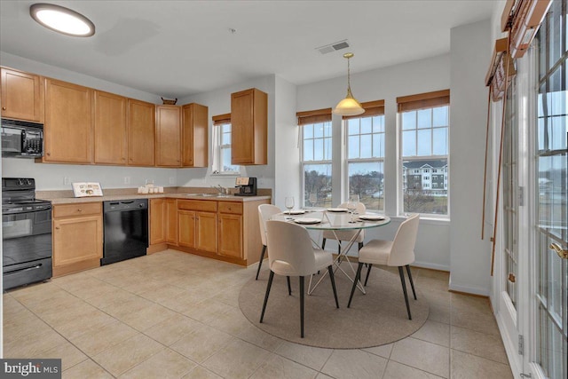 kitchen with sink, decorative light fixtures, light tile patterned floors, and black appliances