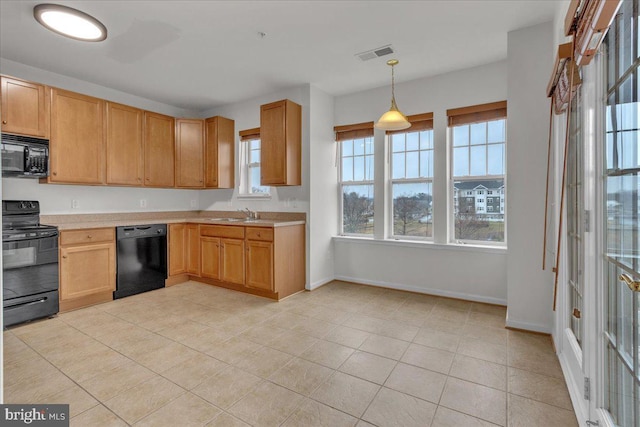 kitchen featuring sink, light tile patterned floors, hanging light fixtures, and black appliances