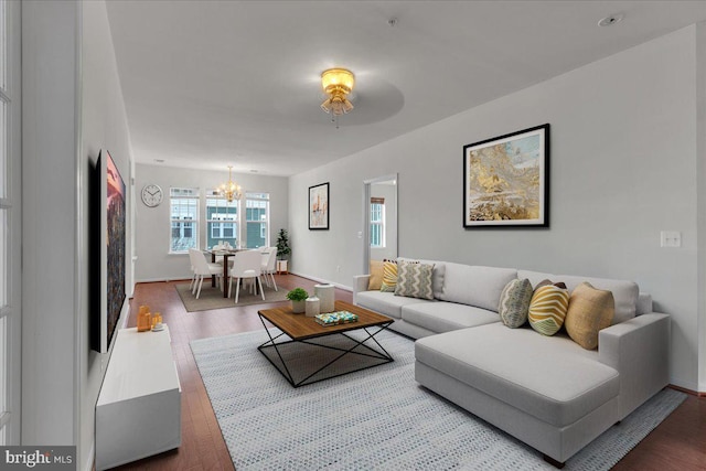 living room featuring wood-type flooring and a notable chandelier