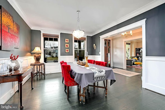 dining room with an inviting chandelier, ornamental molding, and dark hardwood / wood-style floors