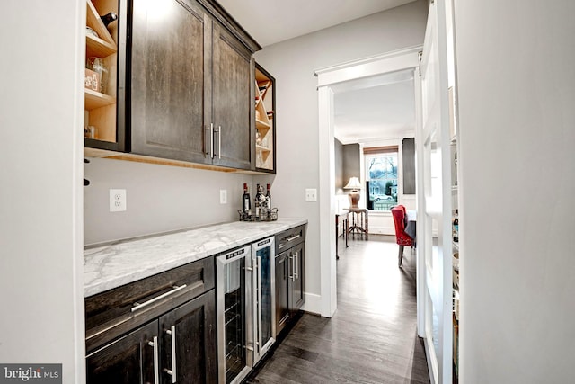 bar featuring dark brown cabinets, dark wood-type flooring, wine cooler, and light stone counters