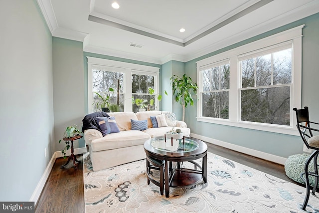 living room featuring crown molding, hardwood / wood-style floors, and a tray ceiling