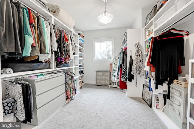 spacious closet featuring light carpet and a notable chandelier