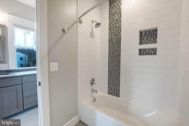 bathroom with tiled shower / bath combo and vanity