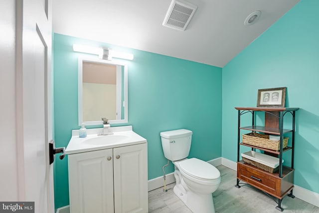 bathroom featuring lofted ceiling, vanity, and toilet