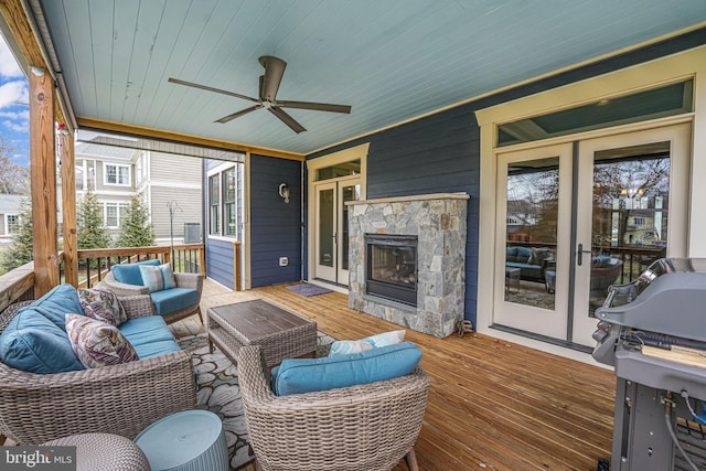 wooden deck featuring an outdoor living space with a fireplace and ceiling fan