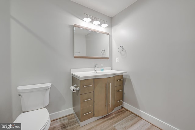 bathroom with vanity, wood-type flooring, and toilet