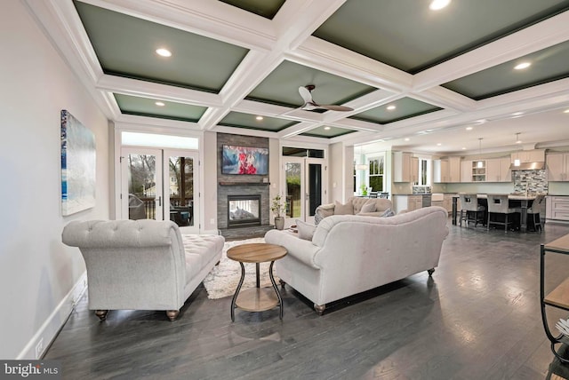 living room featuring beamed ceiling, dark hardwood / wood-style flooring, coffered ceiling, and a fireplace