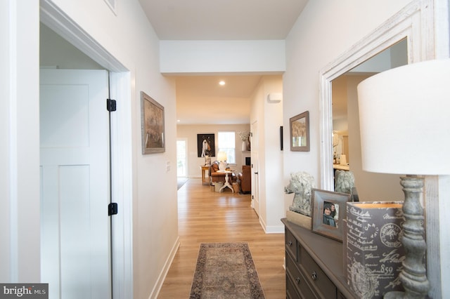 hallway with recessed lighting, light wood-type flooring, and baseboards