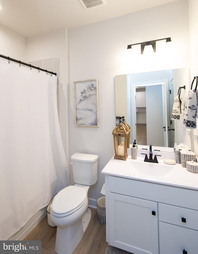 full bath featuring visible vents, toilet, a shower with curtain, wood finished floors, and vanity