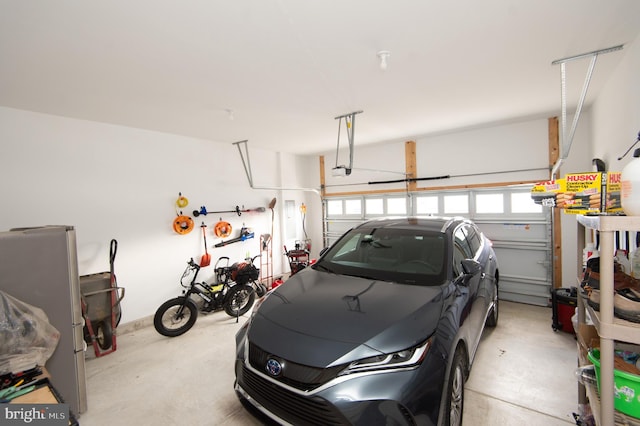 garage featuring freestanding refrigerator and a garage door opener