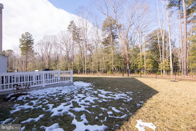 view of yard featuring fence, a deck, and a wooded view