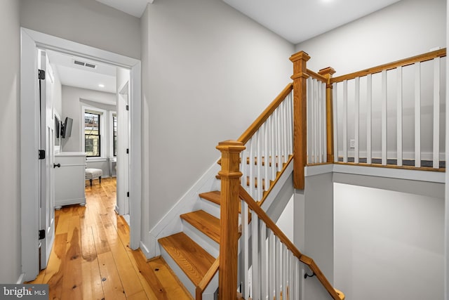 staircase with hardwood / wood-style flooring