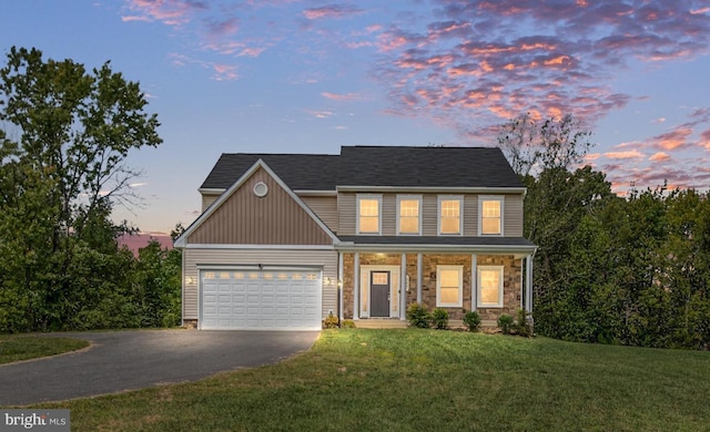 view of front of property with a garage and a lawn