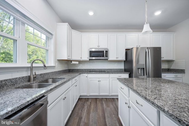 kitchen with white cabinetry, sink, stainless steel appliances, and light stone countertops