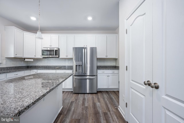 kitchen with stone countertops, decorative light fixtures, appliances with stainless steel finishes, dark hardwood / wood-style flooring, and white cabinets