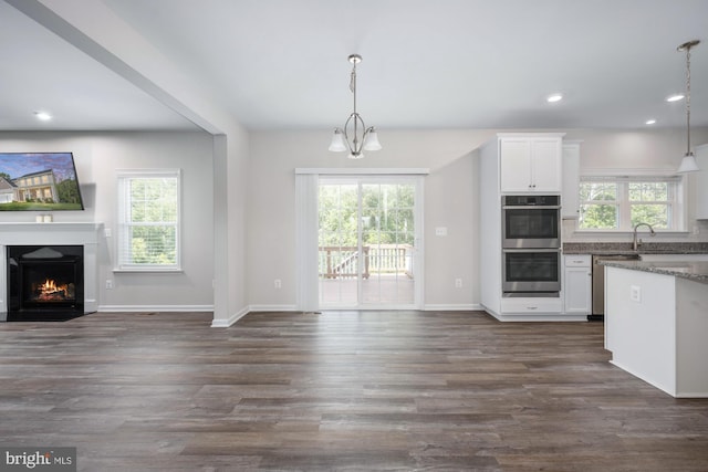 kitchen with pendant lighting, white cabinetry, appliances with stainless steel finishes, and plenty of natural light