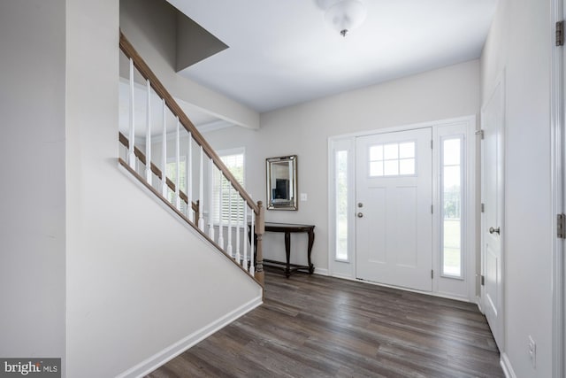 entrance foyer featuring beamed ceiling and dark wood-type flooring