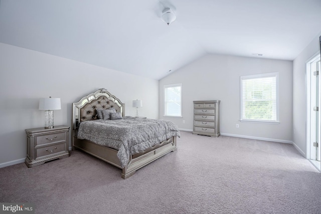 carpeted bedroom with multiple windows and lofted ceiling